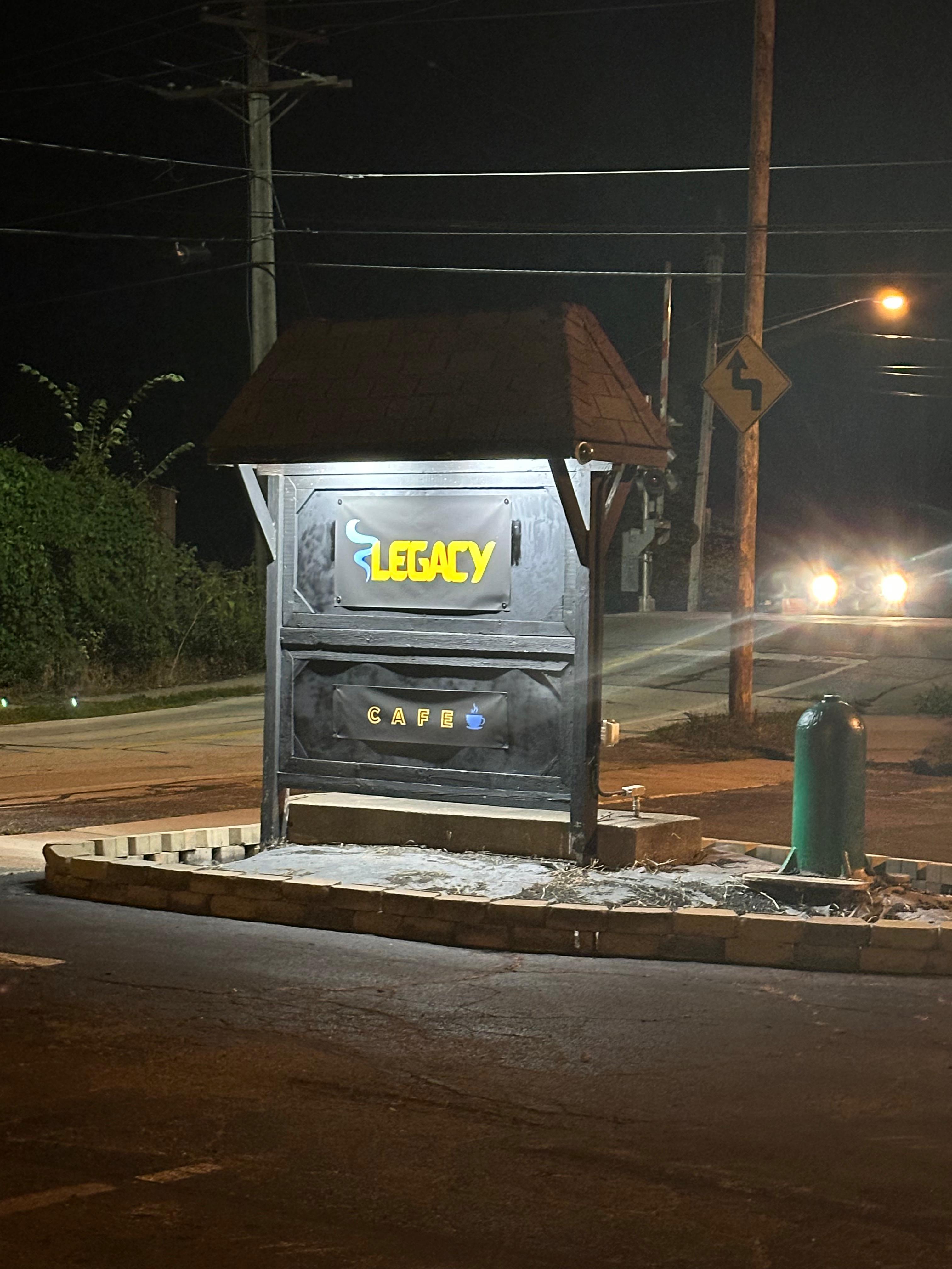 Legacy Cafe illuminated roadside sign at night