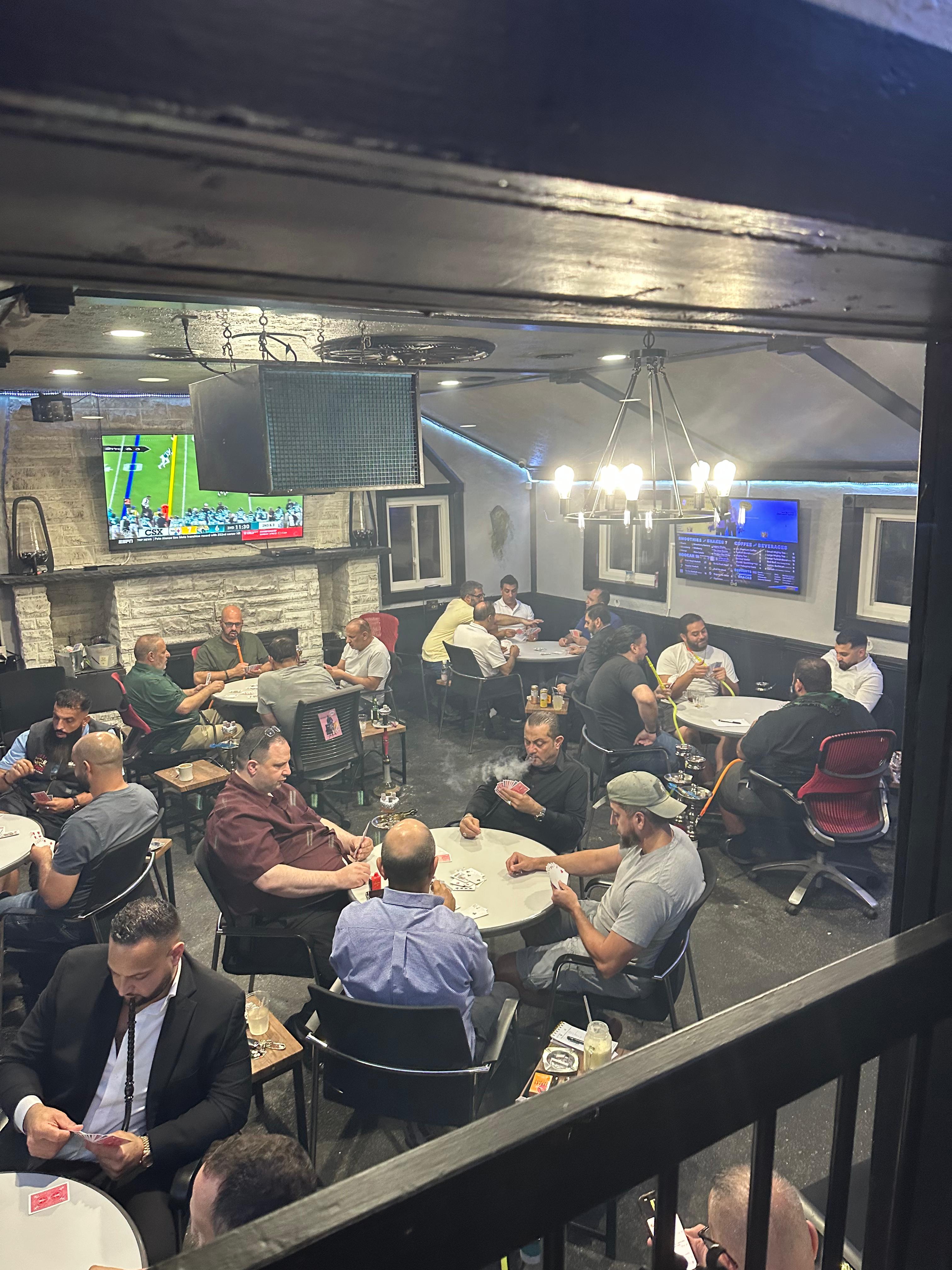 Busy card tournament night at Legacy Cafe — view across tables and TVs